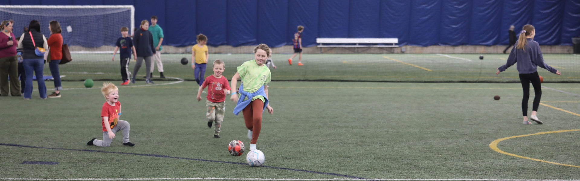 Kids playing soccer in the Plymouth Community Center Fieldhouse