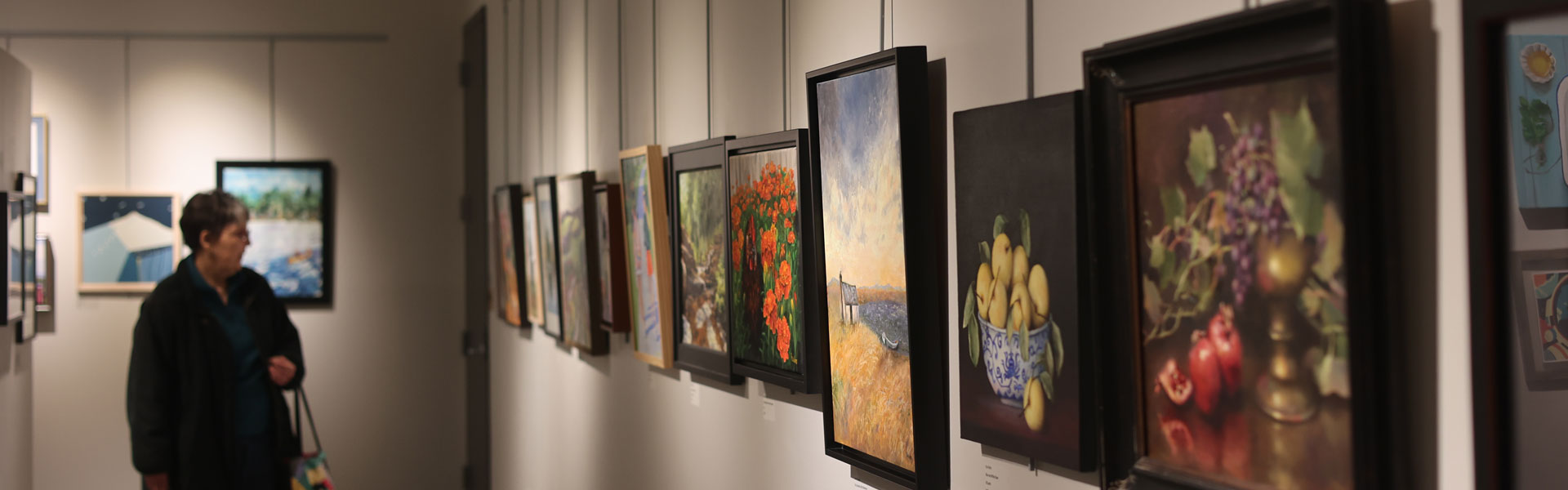 Person looking at art in the art gallery at the Plymouth Community Center